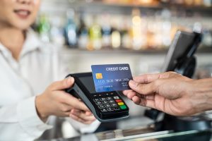 Customer using credit card for payment at cashier in cafe restaurant.