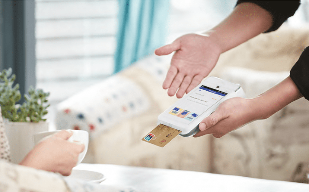 man holding card machine out for lady to pay