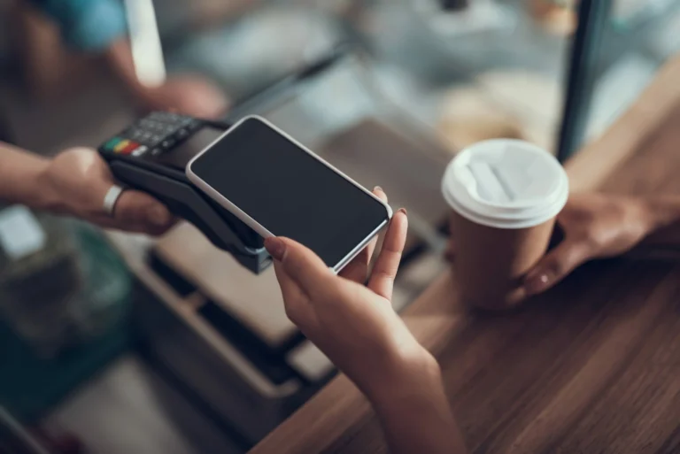 woman paying with mobile for convenience on a card machine in a business