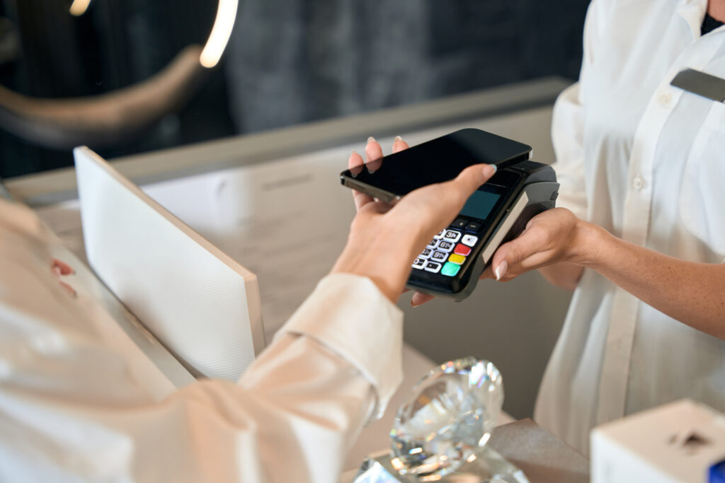 lady choosing her phone and card machine as a payment solution in a salon