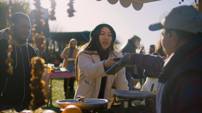 festival vendor taking payment from lady at outdoor market