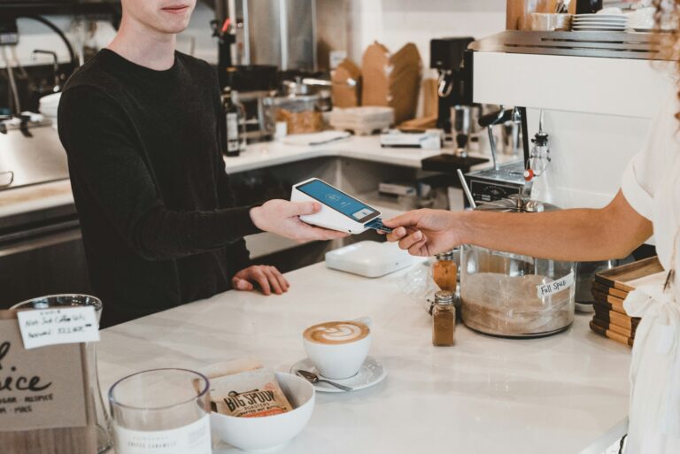 customer paying with card for a coffee in a cafe representing hospitality