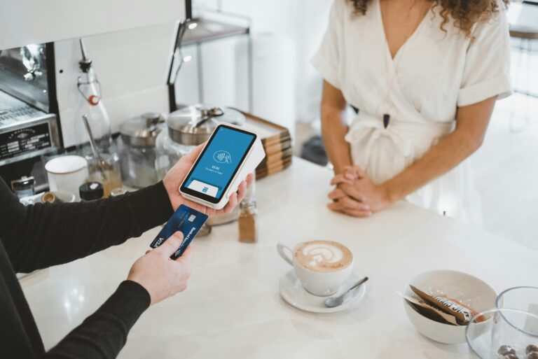 customer paying by card for a coffee in a white minimalistic cafe, representing surcharges