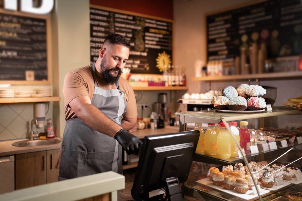 male barista in cafe using EPOS system
