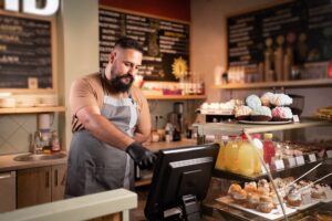 male barista in cafe using EPOS system