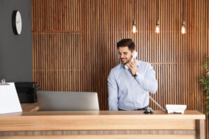 Receptionist talking on phone at desk in lobby representing virtual terminals